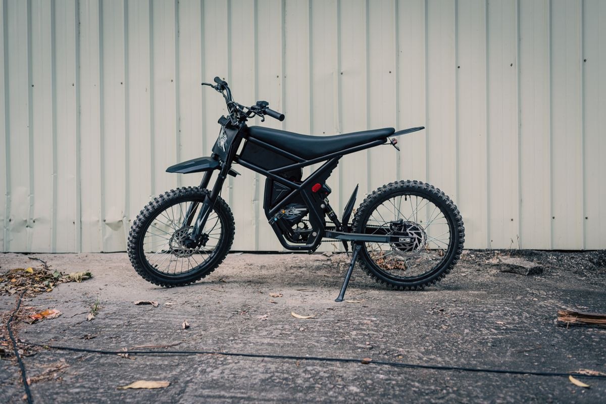 Motocicleta eléctrica negra estacionada sobre una superficie de concreto