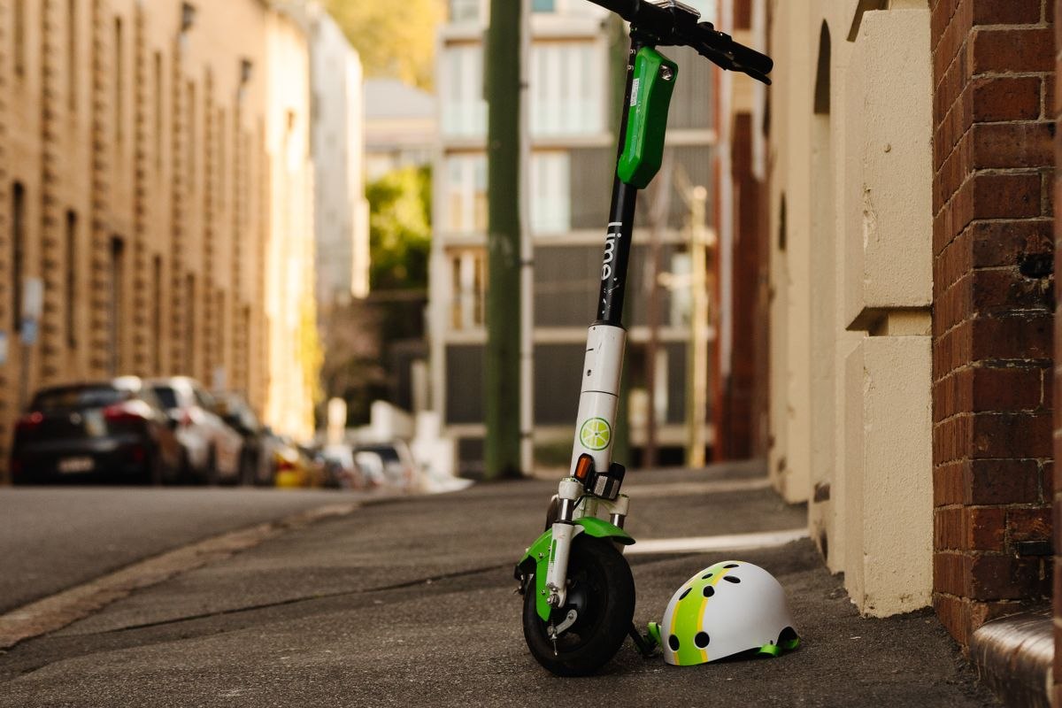 Scooter eléctrico estacionado con un casco sobre el manillar