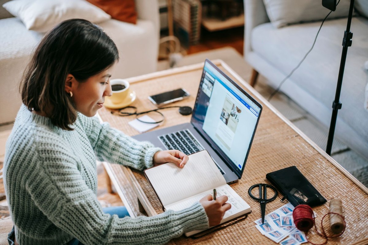 Mujer organizando tareas en una agenda junto a su laptop