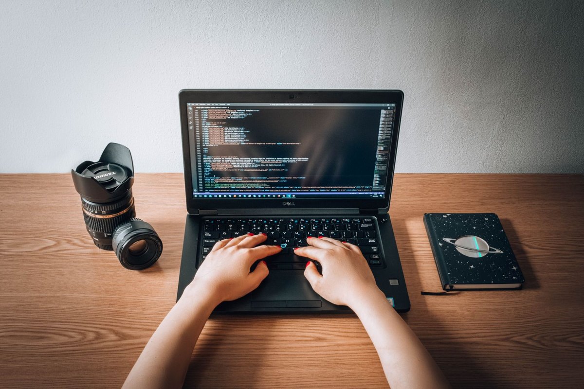 Persona trabajando en el código de una página web desde una laptop