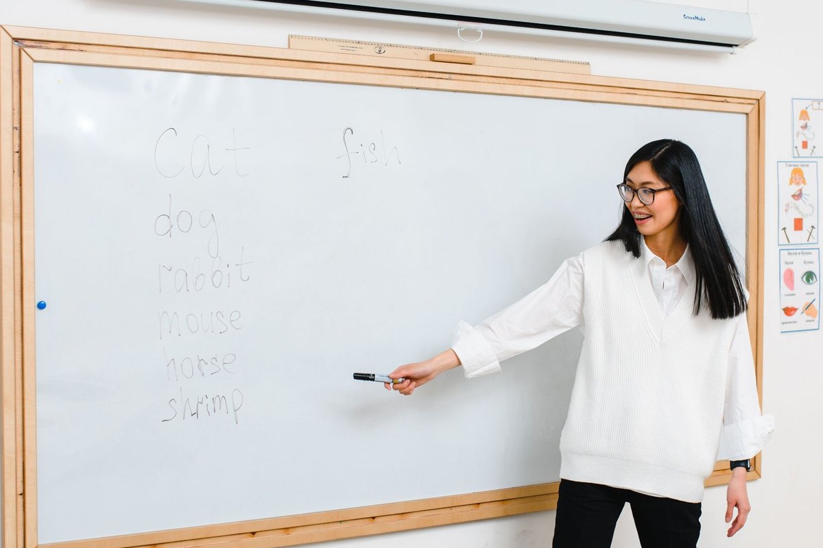 Profesora explicando una lección frente a una pizarra